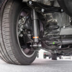 View of a car rear axle assembly with control arm and air suspension shock absorber.