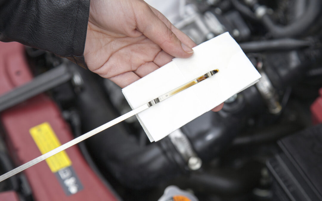 Close up shot of a technician inspecting an Audi's oil dipstick in Georgia.