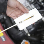Close up shot of a technician inspecting an Audi's oil dipstick in Georgia.