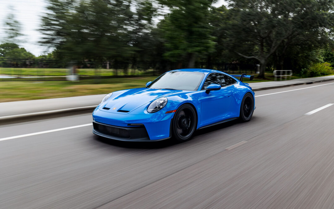 A modern blue Porsche 911 GT3 sports car in motion in Alpharetta, GA.