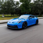 A modern blue Porsche 911 GT3 sports car in motion in Alpharetta, GA.