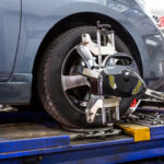 Closeup of tire clamped with aligner, undergoing wheel alignment near Alpharetta, GA.