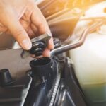 Close-up of mechanic checking the coolant level in an Audi.